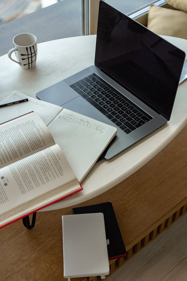 Um laptop e um caderno com anotações de tradução. 