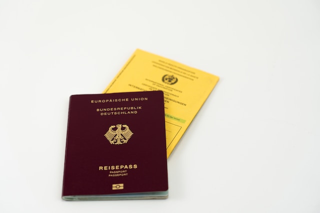 Uma foto de um passaporte vermelho com um certificado amarelo.
