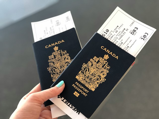 Uma mulher segura dois passaportes canadenses com cartões de embarque.
