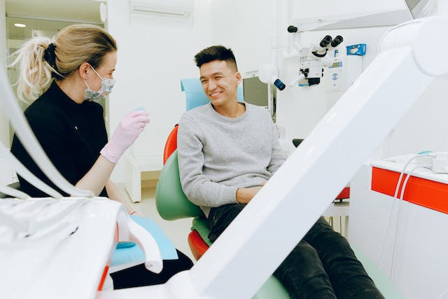 Uma foto de uma equipe médica conversando com um paciente em uma instalação.