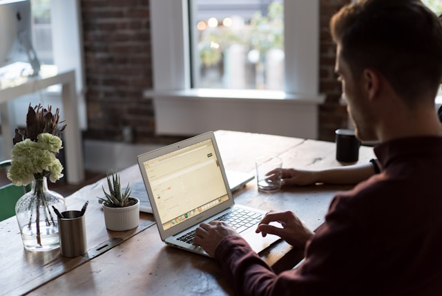 Um homem trabalhando em um laptop em sua casa.