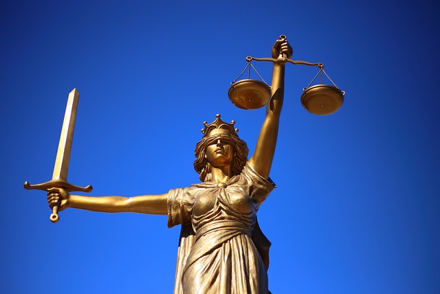 Uma estátua da Lady Justice em um fundo azul.
