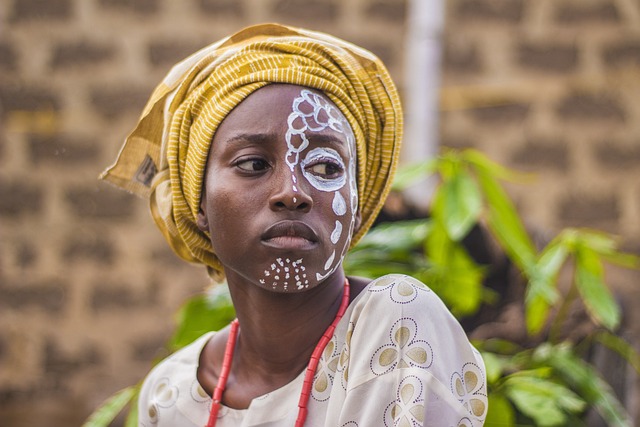 Uma pessoa em trajes tradicionais africanos com pintura facial.
