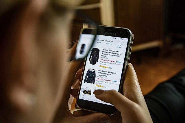 Uma pessoa faz compras de roupas no site da Amazon em um smartphone preto.
