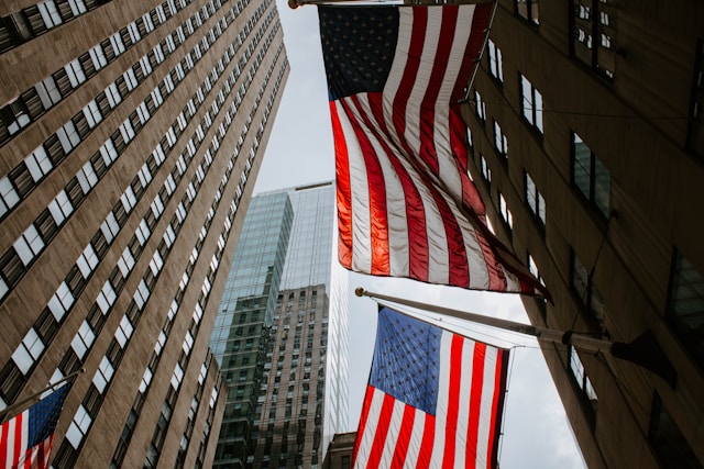 Mastros de bandeiras americanas em um edifício.
