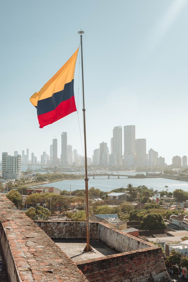 A bandeira colombiana com a linha do horizonte de Cartagena ao fundo. 