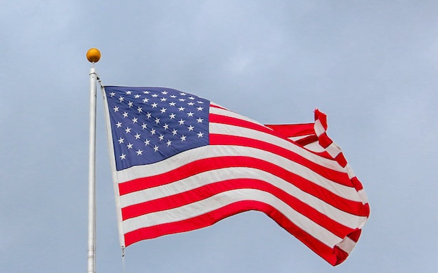 Die Flagge der USA weht an einem weißen Metallmast.