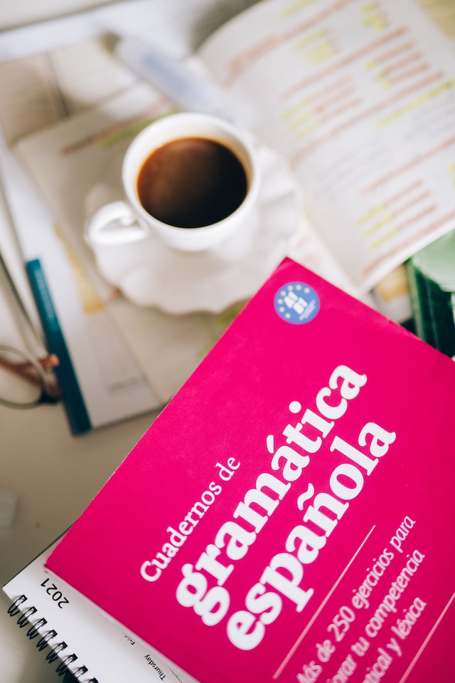 Ein spanisches Grammatikbuch neben einer Tasse Kaffee.