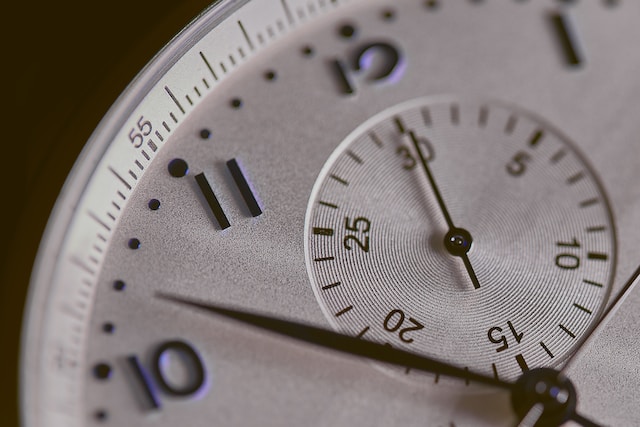 Eine Nahaufnahme des Ziffernblatts einer silbernen Uhr.