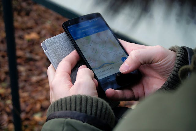 Ein Bild von einer Person, die auf einem mobilen Gerät durch Google Maps navigiert.