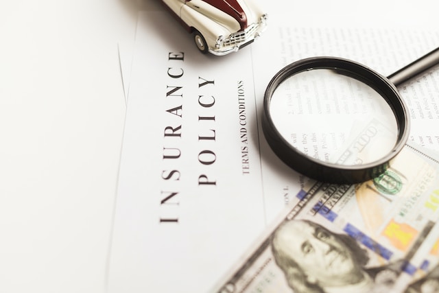 Ein Bild mit einer Lupe und einem Dollarschein auf einer Versicherungspolice.