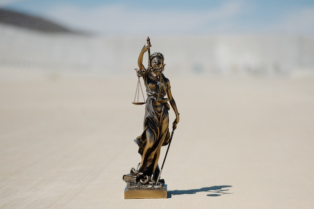 Eine Bronzestatue von Lady Justice, die eine Waage und ein Schwert hält. 