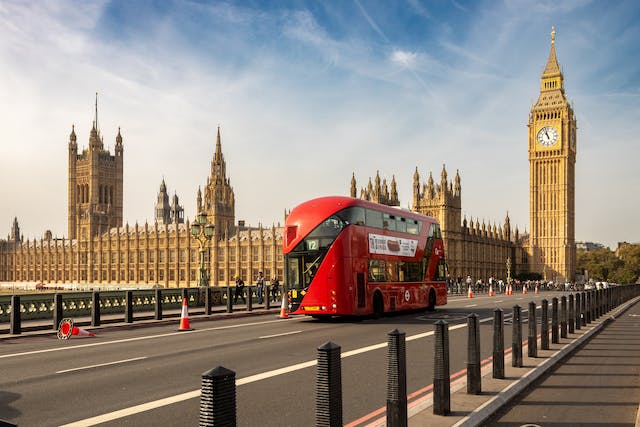 Ein roter Hop-on-hop-off-Bus in London fährt am Big Ben vorbei.