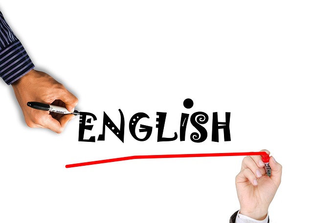 Eine Hand schreibt "ENGLISH" auf ein Whiteboard, eine andere Hand unterstreicht das Wort.
