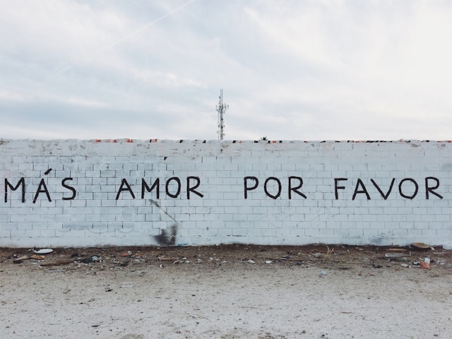 Eine graue Betonwand mit spanischen Worten in schwarzer Tinte.