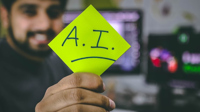 Eine Person hält eine grüne Karte mit der Aufschrift "AI".
