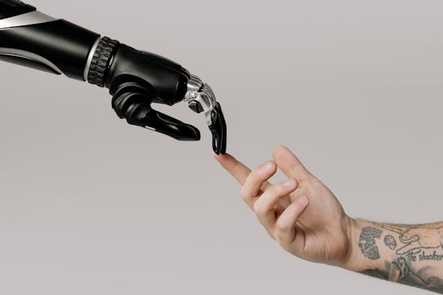 Ein Roboter berührt die Hand eines Menschen.
