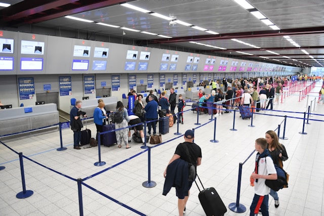 Menschen warten in einer Schlange auf einem Flughafen. 
