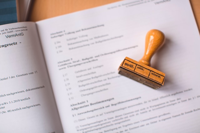 Imagen de un sello de madera marrón en una página abierta de un folleto.