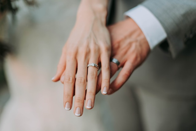 Una imagen de dos personas con alianzas cogidas de la mano.