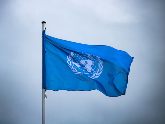 Una bandera de las Naciones Unidas ondeando al viento.
