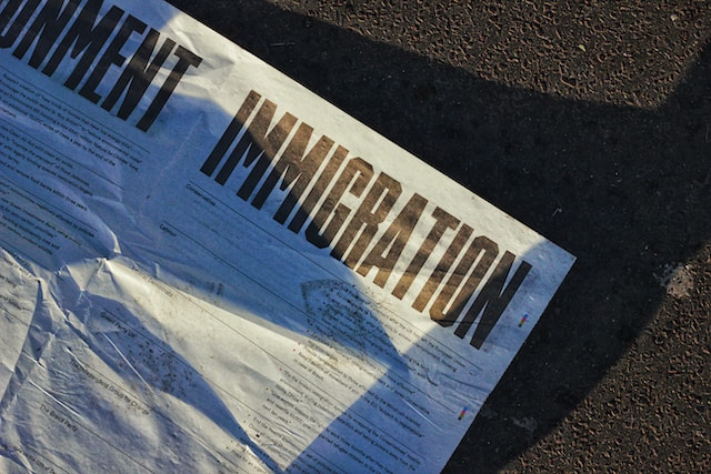 Un papier portant l'inscription "Immigration" est posé sur le sol.