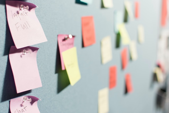 Une photo de plusieurs blocs-notes fixés à un mur bleu.