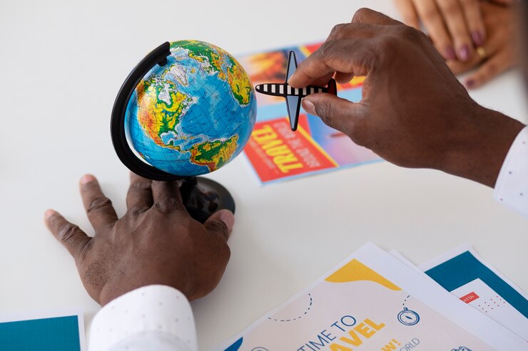 Une personne place une petite figurine d'avion sur un mini globe.