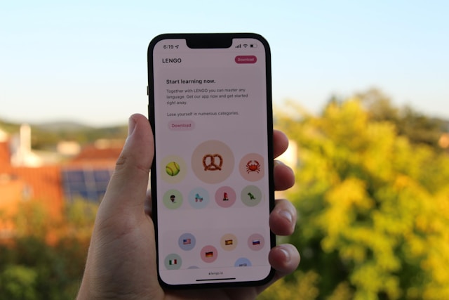 Une personne tient un smartphone avec une application d'apprentissage des langues ouverte.
