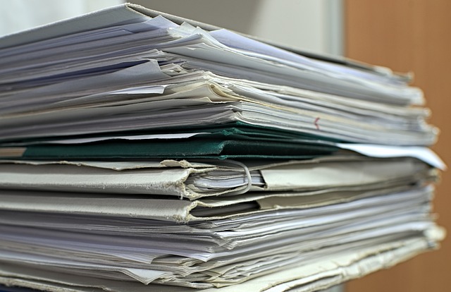 Une pile de dossiers contient d'anciens documents.
