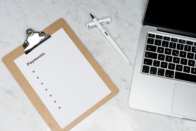 Une feuille de facture avec un stylo à côté d'un ordinateur portable sur une table.
