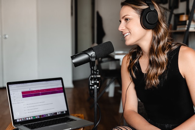 Une personne enregistre sa voix dans un ordinateur portable à l'aide d'un microphone. 
