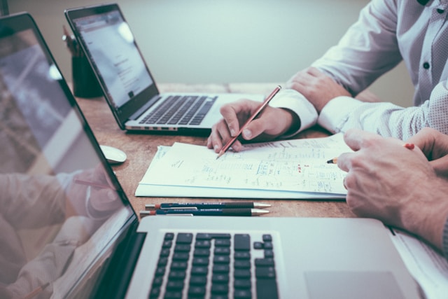 Deux personnes travaillent à la traduction d'un document au bureau. 
