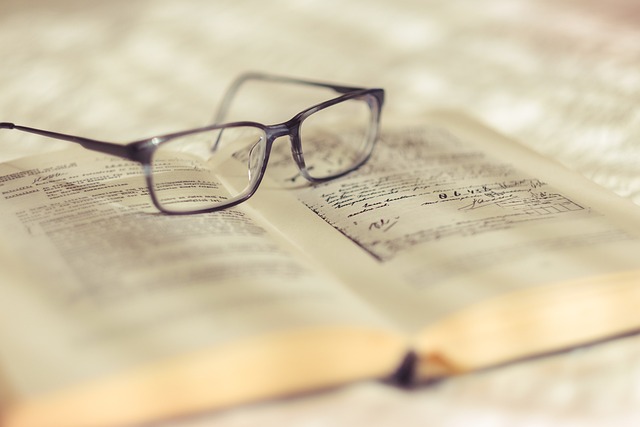 Une paire de lunettes de lecture est posée sur un livre ouvert.