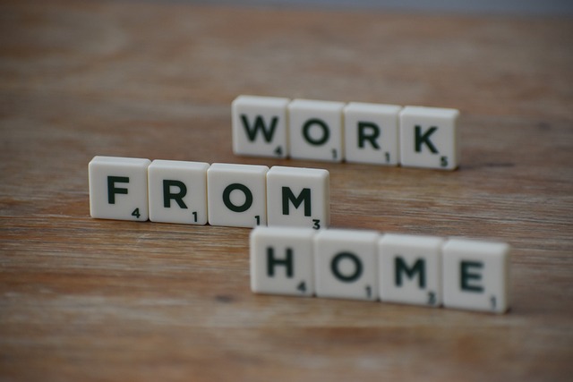 Des carreaux de scrabble horizontaux écrivent "Travail à domicile" sur une surface en bois.