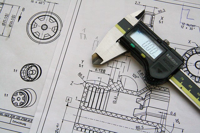 Vue rapprochée d'un pied à coulisse et de dessins techniques sur un document.