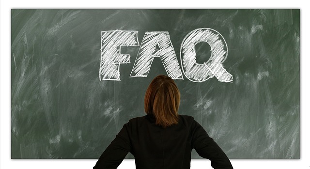 कोई व्यक्ति खड़ा होकर चॉकबोर्ड पर लिखे संक्षिप्त नाम “FAQ” को देख रहा है।
