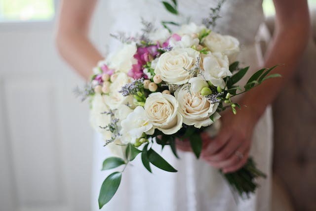 L'immagine di una sposa con un bouquet bianco in mano.