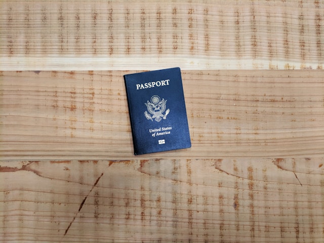Un passaporto americano blu su un tavolo di legno. 
