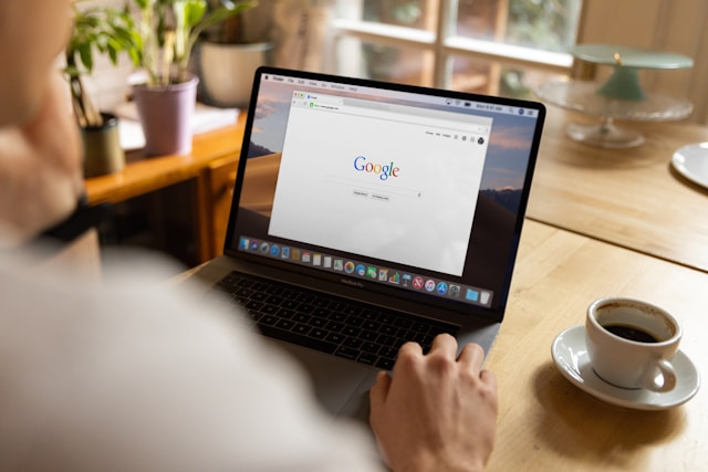 Una persona guarda lo schermo di un computer portatile che visualizza la pagina di ricerca di Google.