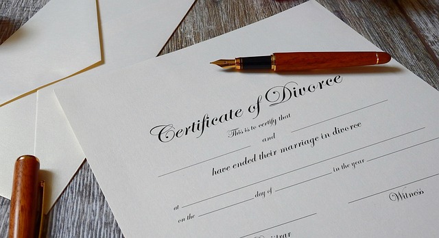 Una penna si trova su un certificato di divorzio vuoto posto su una superficie di legno.
