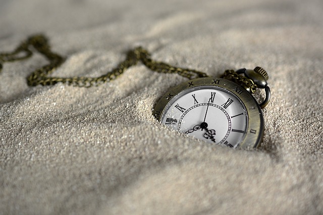 Un cronometro è semisepolto nella sabbia bianca.
