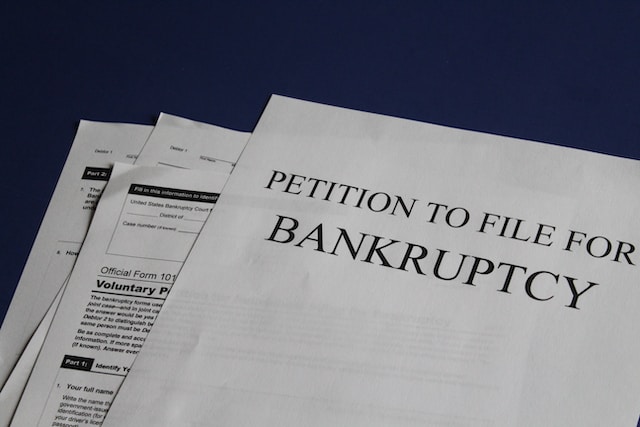 A photo of a printed petition to file for bankruptcy on a table.