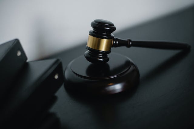 A closeup picture of a wooden gavel on a table.
