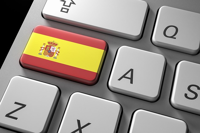 Close-up view of the Spanish flag and emblem on a computer keyboard.
