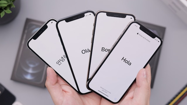 Smartphone screens display different language versions of the word hello. 
