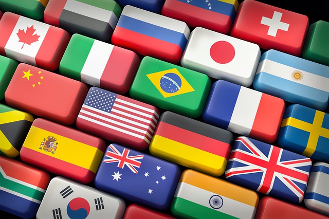 Different country flags are on a computer keyboard.
