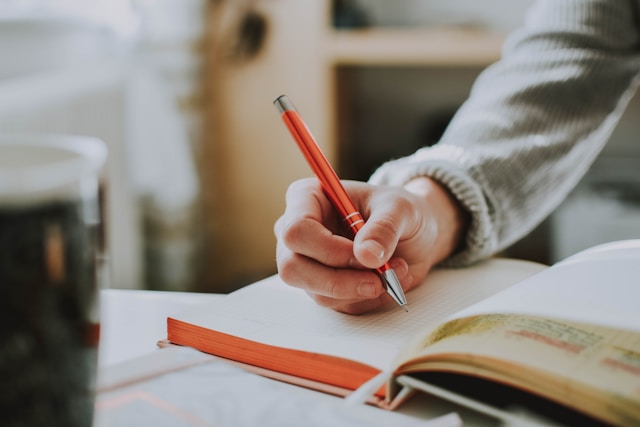 A person writes in a journal.
