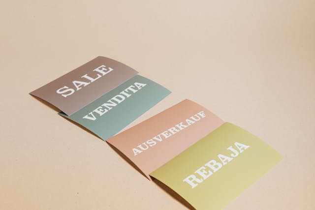 Several pieces of paper with the word “Sale” in different languages.
