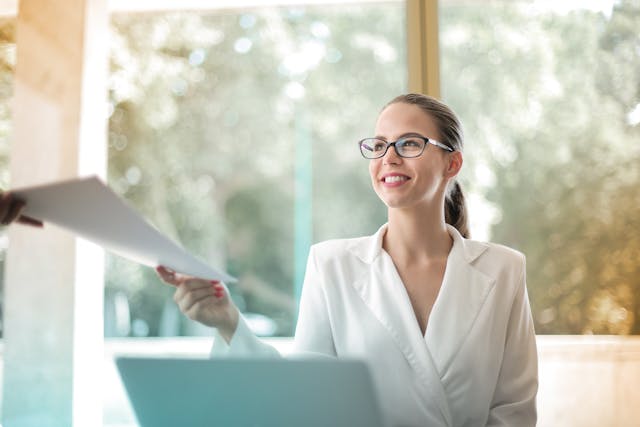 A person gives over a document to another.
